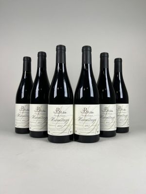six bottles of red wine lined up in a row