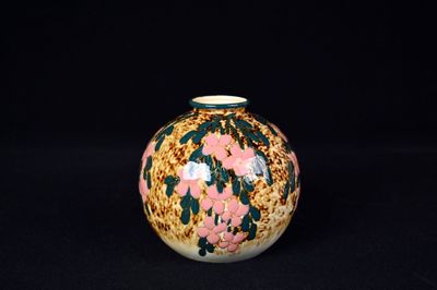 un petit vase orné de fleurs sur fond noir