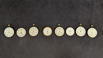 Plusieurs horloges sont disposées en rangée sur une surface noire