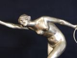 statue of a woman holding a tennis racquet on a black background