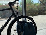 a bicycle parked in front of a window with a bag on it