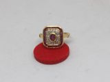 an image of a gold ring with a ruby stone in it