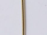 a gold stick with a diamond on it on a white surface