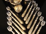 a lot of silverware sitting on a black table