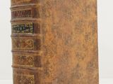 an old book sitting on top of a white surface