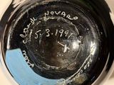 a close up of a black vase with writing on it