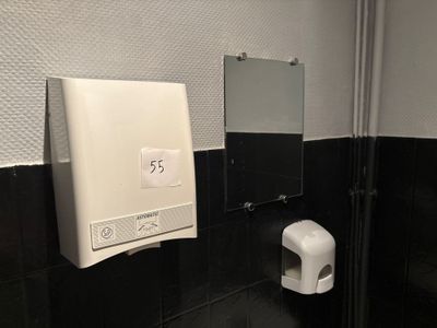 des toilettes avec un distributeur de papier dans un coin