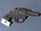 un petit pistolet muni d'une étiquette, posé sur une table