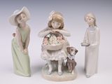 trois figurines représentant des enfants et un chien posées sur une table