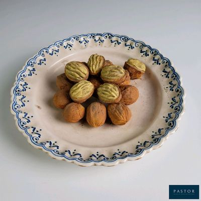 une assiette posée sur une table, sur laquelle se trouvent des noix et des noisettes