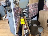 a lamp that is on a tripod next to a pile of books