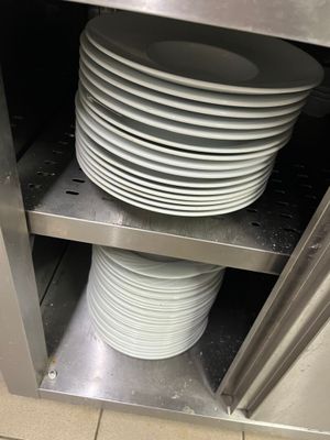 une pile d'assiettes posée sur une étagère dans une cuisine
