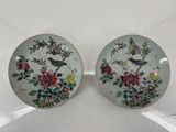 deux assiettes ornées de fleurs et d'oiseaux, posées sur une table