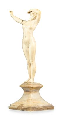 an ivory figure of a woman on a pedestal with her arms outstretched