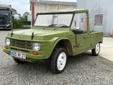 un camion vert garé devant un immeuble