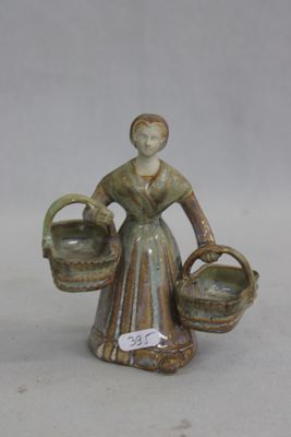 une figurine représentant une femme tenant deux paniers