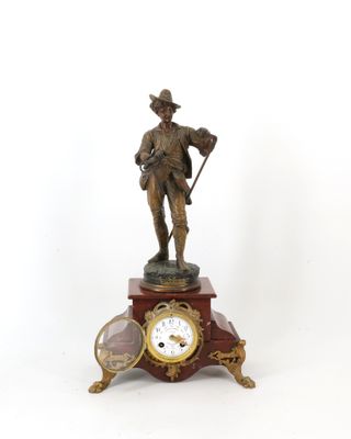 une statue représentant un homme tenant une canne et une horloge