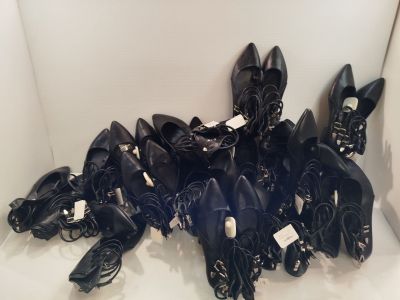 de nombreuses paires de chaussures noires qui traînent par terre