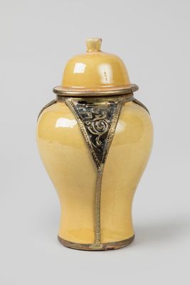an image of a yellow vase with a lid sitting on a table
