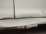 a white car with rust on the side of it