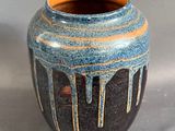 un vase bleu et orange posé sur une table
