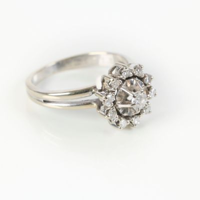 a close up of a diamond ring on a white surface