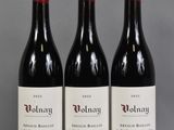 trois bouteilles de vin rouge posées sur une table