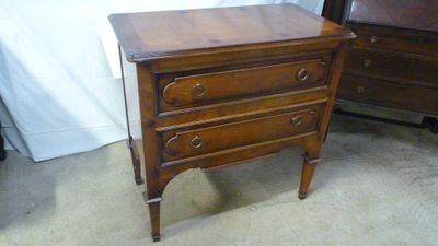 une petite commode en bois dans un coin de la pièce