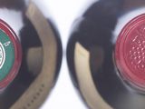 two bottles of wine sitting next to each other on a table