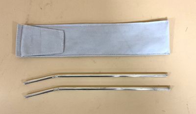 une paire de pailles en métal et une paire de ciseaux posés sur une table