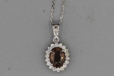 un pendentif en forme de losange marron et blanc, monté sur une chaîne