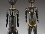 two wooden figures of a man and a woman standing next to each other