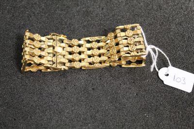 a gold bracelet that has a tag on it