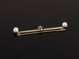 a close up of a gold and pearl broocher