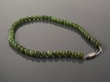 a close up of a green beaded necklace on a table