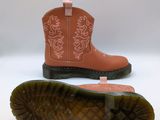 two pairs of pink cowboy boots sitting on top of a white surface