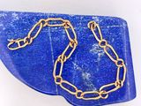 collier bleu et or, composé d'une chaîne dorée posée sur une plaque bleue