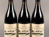 trois bouteilles de vin posées l'une à côté de l'autre sur une table