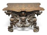 an ornately carved table with two lions and a bird on it