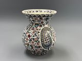 un vase orné d'un motif floral sur un fond gris