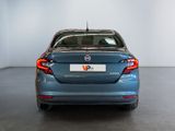 the back end of a blue car in a room with a white wall