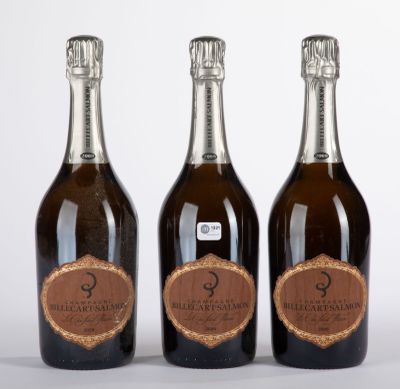 three bottles of champagne sitting next to each other on a white surface