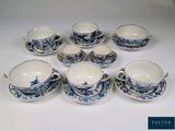 six tasses et soucoupes en porcelaine bleue et blanche posées sur une table blanche