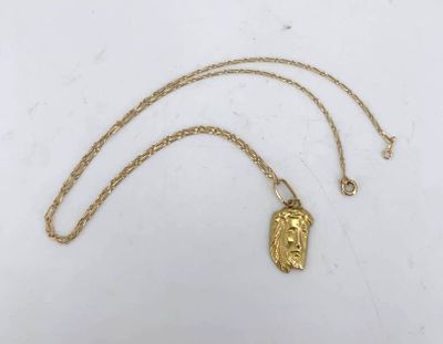 a gold necklace with a face of jesus on it