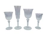 trois verres à pied en verre transparent et un verre à vin sur fond blanc