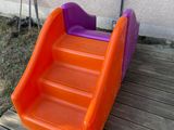 an orange and purple plastic slide on a wooden deck