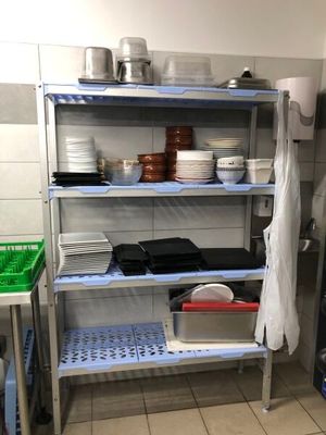 a metal shelf with dishes on it in a kitchen