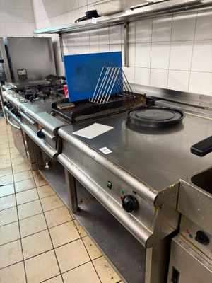 une cuisinière dans une cuisine, sur laquelle se trouve une boîte bleue