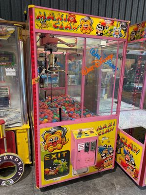une machine à pinces rose et jaune installée devant d'autres machines