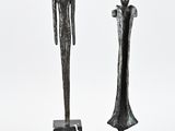 deux sculptures représentant un homme et une femme debout l'un à côté de l'autre